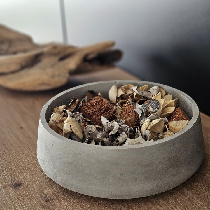 Wide concrete bowl filled with dried botanicals and seed pods