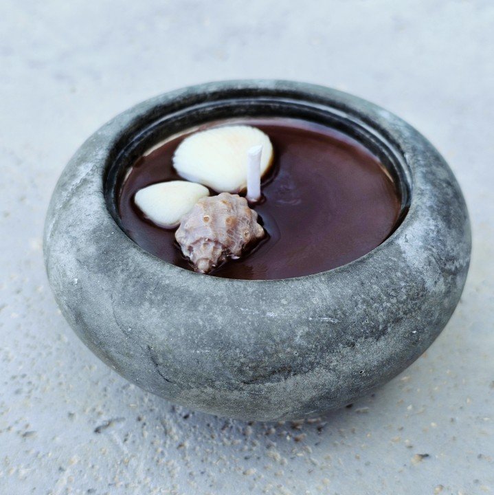 Round concrete bowl candle with seashells set in dark wax